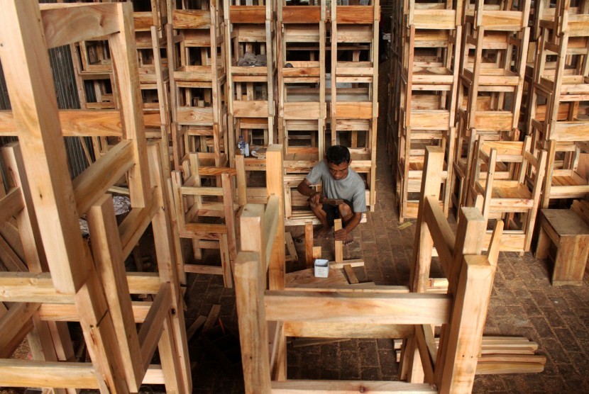 Pekerja menyelesaikan pembuatan kursi dan meja sekolah, di sentra industri mebel, kawasan Kranji, Bekasi, Jawa Barat, Rabu (4/7).