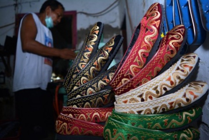 Pekerja menyelesaikan pembuatan sepatu bordir di industri rumahan kawasan Kampung batik Jetis, Sidoarjo, Jawa Timur, Rabu (23/12).