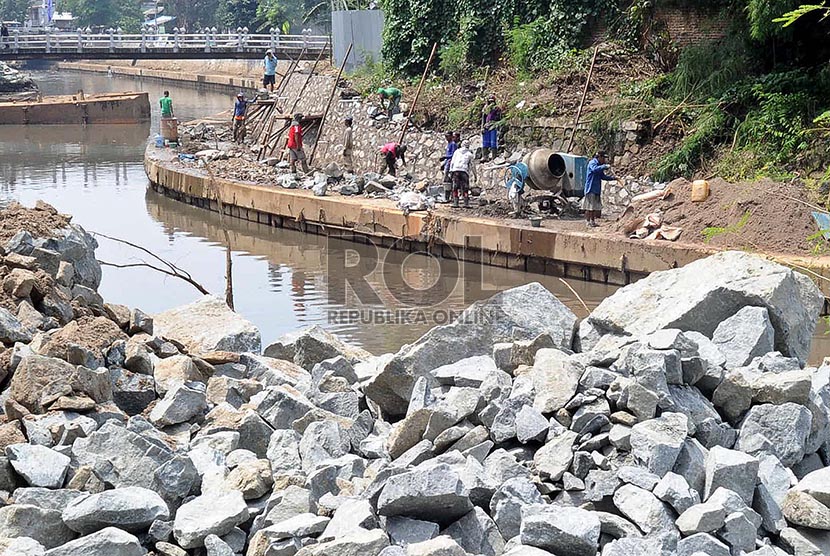 Pekerja menyelesaikan pembuatan tanggul di Kali Inspeksi Ciliwung, Jakarta Pusat, Kamis (20/2).