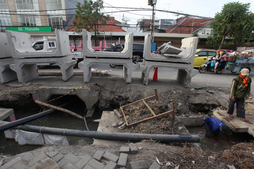 Pekerja menyelesaikan pengerjaan saluran air di Jalan Ambengan, Surabaya, Jawa Timur, Jumat (16/9/2022). Pemkot Surabaya melakukan pembangunan saluran-saluran air di sejumlah lokasi untuk mengantisipasi banjir saat musim hujan. 