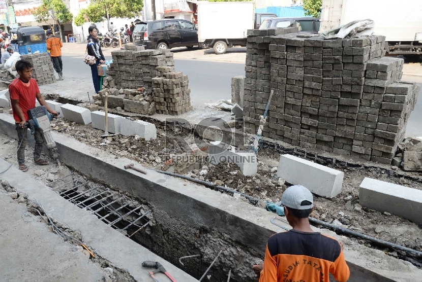 Pekerja menyelesaikan perbaikan saluran air di Jalan Sabang, Jakarta Pusat, Rabu (11/11).     (Republika/Yasin Habibi)