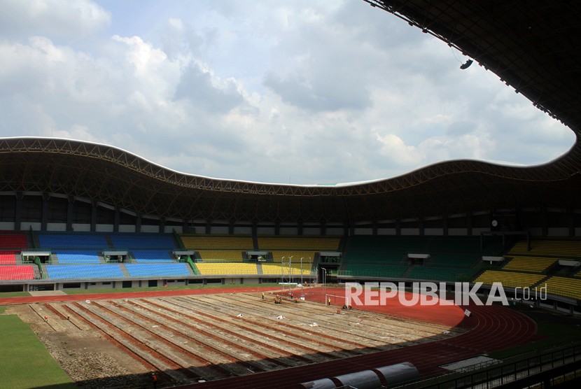 Pekerja menyelesaikan pergantian rumput lapangan Stadion Patriot Candrabhaga, di Bekasi, Jawa Barat.