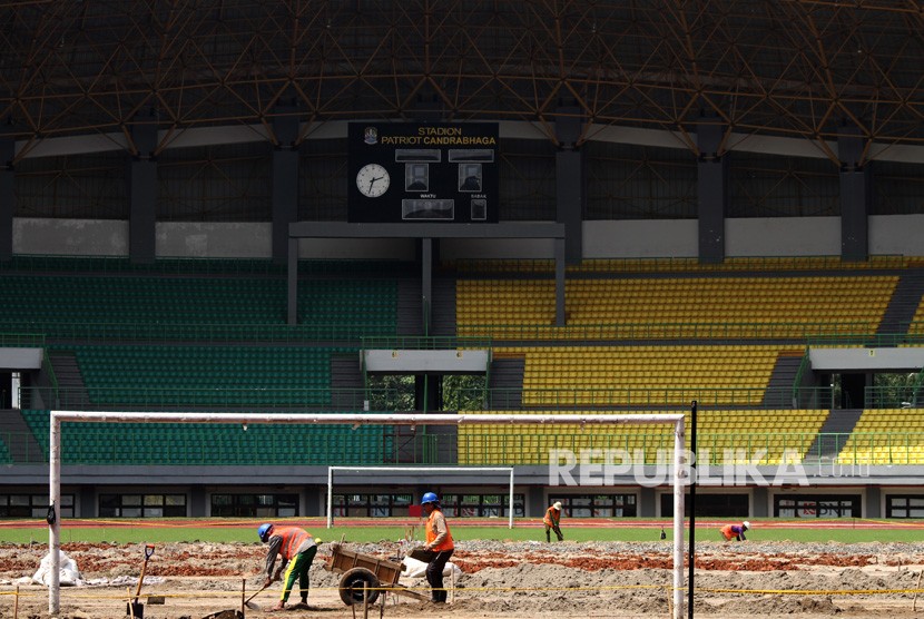 Pekerja menyelesaikan pergantian rumput lapangan Stadion Patriot Candrabhaga, di Bekasi, Jawa Barat, Selasa (20/2).