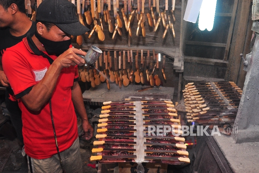 Pekerja menyelesaikan proses pemasangan aksesoris pada miniatur body gitar di Turasan, Manjungan, Ngawen, Klaten, Jawa Tengah, beberapa waktu lalu. ANTARA FOTO/Aloysius Jarot Nugroho/kye/15.