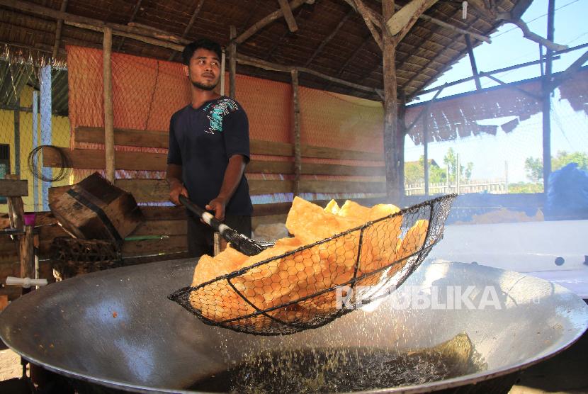 Pekerja menyelesaikan proses penggorengan kerupuk di salah satu sentra produksi kerupuk rumahan Desa Suak Ribe, Johan Pahlawan, Aceh Barat, Aceh, Senin (25/2). Kementerian Koperasi dan Usaha Kecil Menengah (UKM) akan menggandeng Otoritas Jasa Keuangan untuk mendata UMKM.