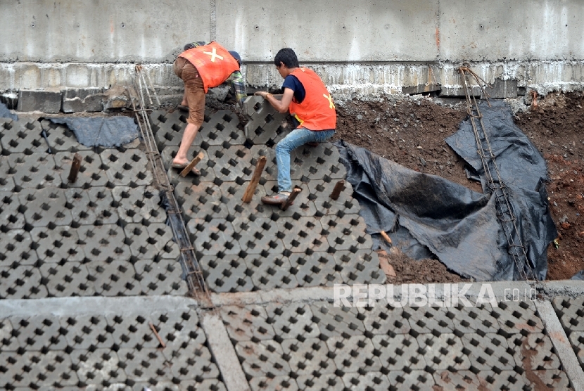  Pekerja menyelesaikan proyek normalisasi Sungai Ciliwung di Bukit Duri, Jakarta. 