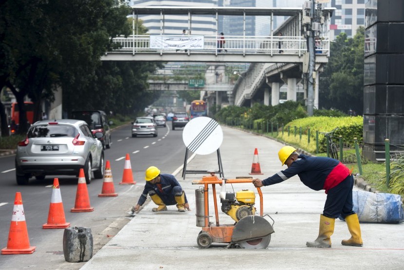 Pekerja menyelesaikan proyek perbaikan dan pemeliharaan jalan lajur TransJakarta Koridor I di Jalan Jenderal Sudirman, Jakarta, Rabu (16/3).