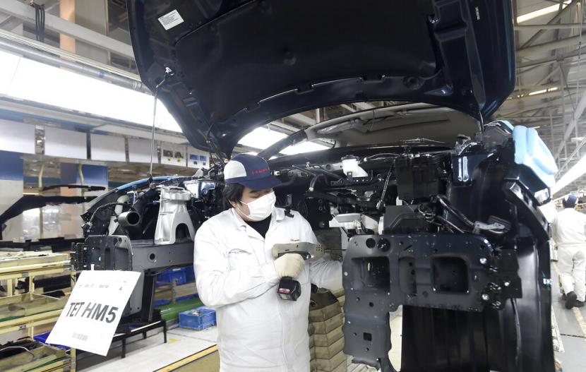 Pekerja menyelesaikan rakitan kendaraan di pabrik Dongfeng, Provinsi Hubei, China. Indeks pembelian manajer China tercatat meningkat pada Februari.