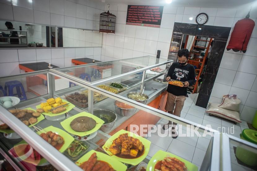 Pekerja menyiapkan lauk pauk di Warteg Subsidi Bahari, Pejaten, Kecamatan Pasar MInggu, Jakarta Selatan. Pemerintah kini membolehkan pengunjung makan di tempat maksimal 20 menit.