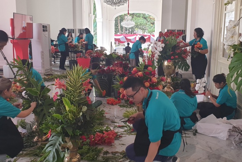 Pekerja menyiapkan rangkaian bunga untuk dekorasi 17 Agustus di Istana Negara, Jumat (16/8). 