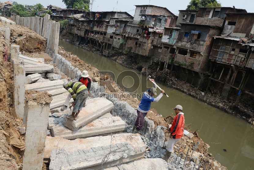 Pekerja menyiapkan tiang pancang yang digunakan untuk pemasangan turap bantaran Sungai Ciliwung di Kampung Pulo, Jakarta, Ahad (6/9).   (Republika/Yasin Habibi)