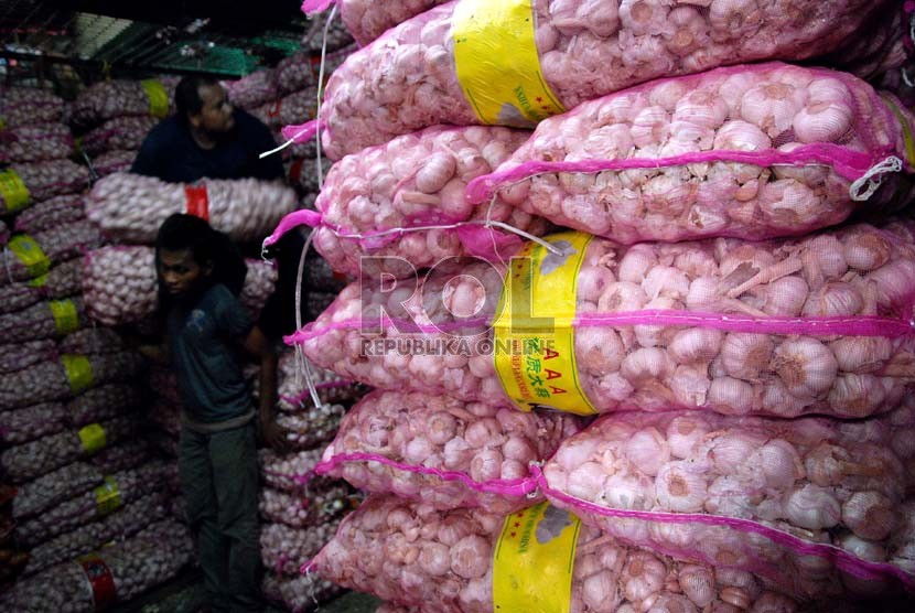  Pekerja menyusun bawang putih impor saat bongkar muat di Pasar Induk Kramat Jati,Jakarta,Senin (10/12).    (Republika/Prayogi)