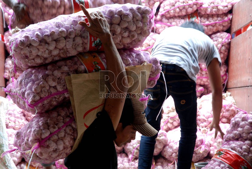  Pekerja menyusun bawang putih impor saat bongkar muat di Pasar Induk Kramat Jati,Jakarta,Senin (10/12).    (Republika/Prayogi)