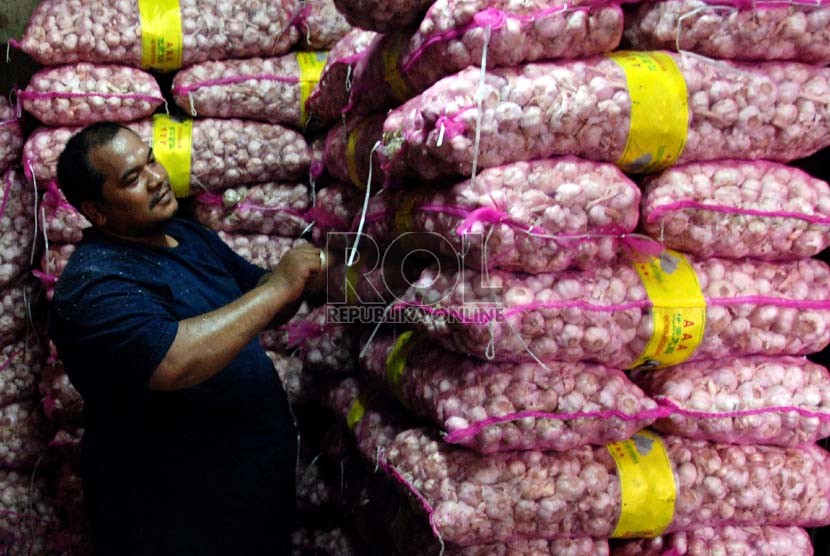 Pekerja menyusun Bawang Putih impor saat bongkar muat di Pasar Induk Kramat Jati, Jakarta, Senin (10/12).