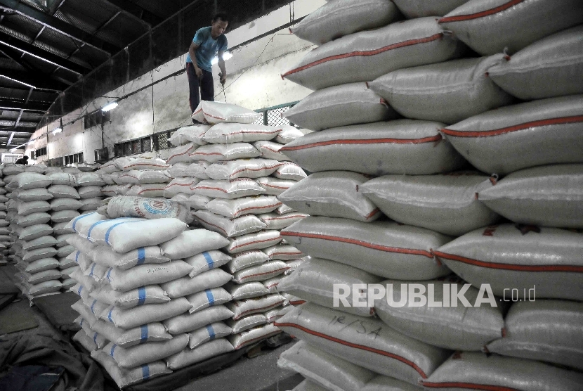 Pekerja menyusun karung beras di Pasar Induk Cipinang, Jakarta, Senin (2/1). 