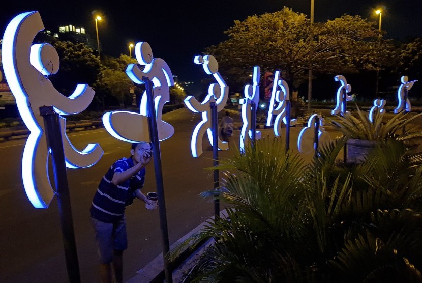 Pekerja merampungkan pemasangan lampu pernak-pernik logo Asian Games dipasang di kawasan Kemayoran, Jakarta, Kamis (23/11).