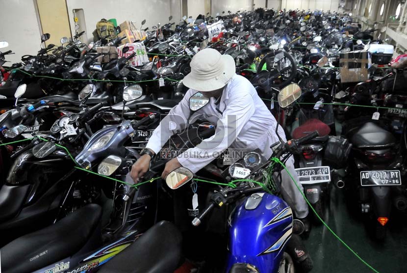   Pekerja merapihkan motor pemudik dalam KM Dobonsolo yang akan diberangkatkan ke Semarang dari Pelabuhan Tanjung Priok, Jakarta, Sabtu (3/8).  (Republika/Prayogi)