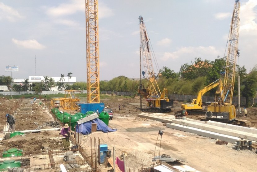Pekerja merapikan besi-besi tiang pancang proyek Bintara Residence.