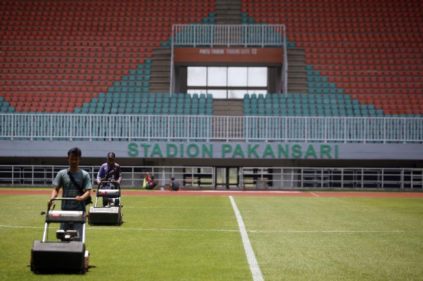 Pekerja merapikan rumput Stadion Pakansari, di Kabupaten Bogor, Jawa Barat, Senin, (26/9/2022). Stadion Pakansari dengan kapasitas 30 ribu penonton itu menjadi tempat pertandingan laga sepak bola Internasional FIFA Matchday leg ke-2 antara Indonesia vs Curacao pada Selasa (27/9/2022). 
