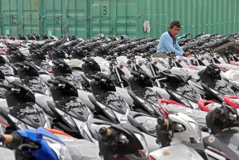 Pekerja merapikan sepeda motor yang siap dikirim ke sejumlah daerah di Pelabuhan Tanjung Priok, Jakarta.  