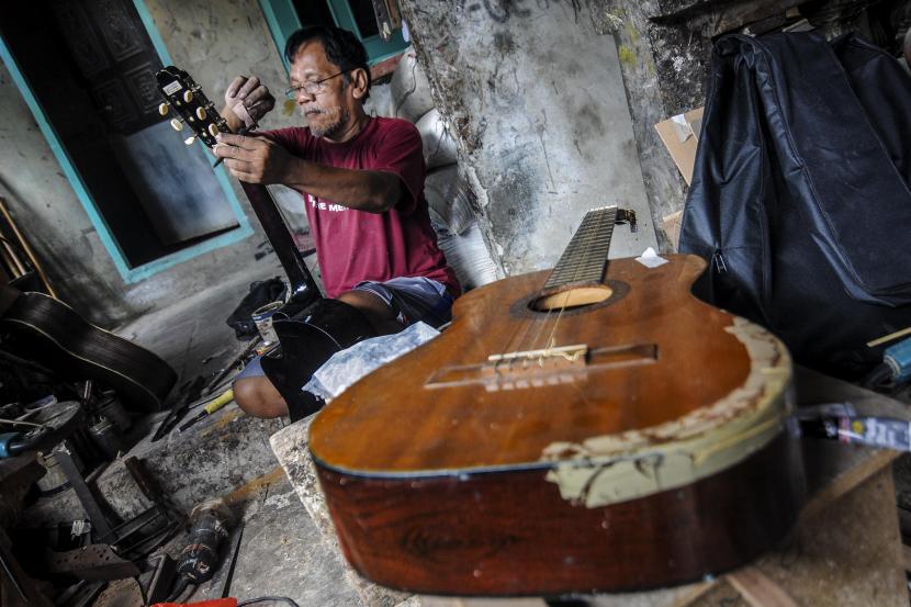 Pekerja mereparasi gitar di kawasan Pasar Minggu, Jakarta.