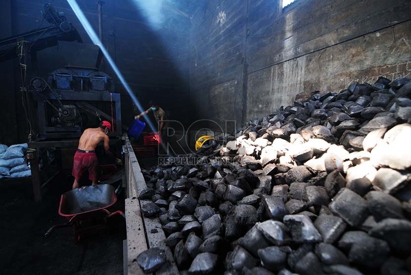  Pekerja mewadahi briket batubara yang sudah di cetak di  lingkungan balai pengembangan perindustrian sub unit pengembangan IKM logam, Gedebage, Kota Bandung, Kamis (6/8). (foto : Septianjar Muharam)