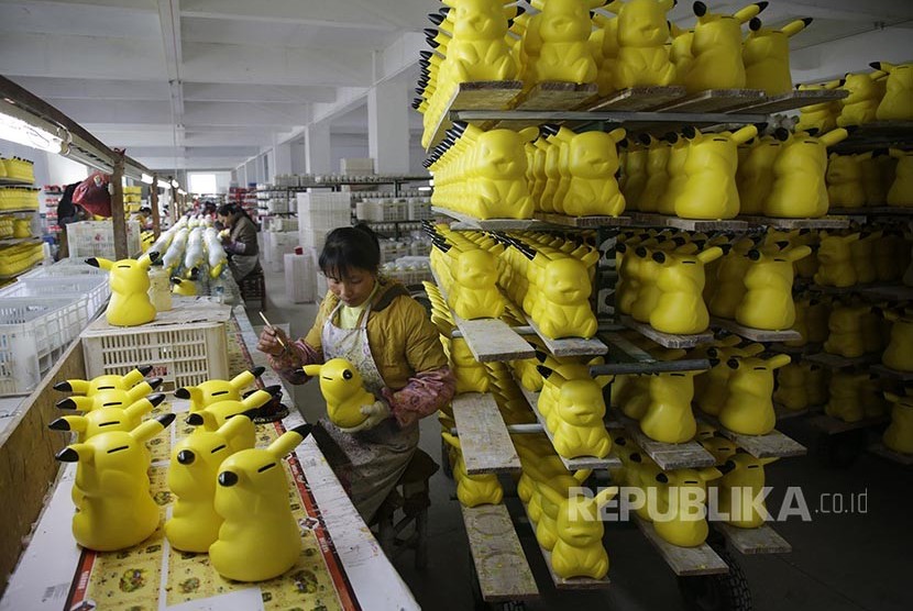 Pekerja mewarnai celengan berbentuk Picachu di sebuah pabrik di Provinsi Fujian, China.