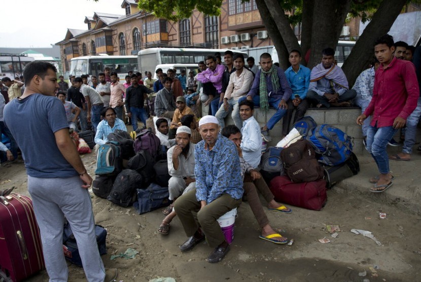 Pekerja migran India menunggu bus di Srinagar untuk keluar dari Kashmir, Selasa (6/8). Karena Kashmir diisolasi, ratusan pekerja ini kembali ke desanya di utara dan timur India.