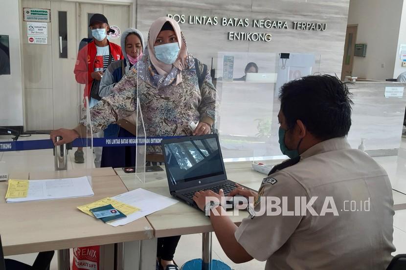 Pekerja Migran Indonesia (PMI) dari Malaysia menjalani pemeriksaan dokumen oleh petugas Kantor Kesehatan Pelabuhan di Pos Lintas Batas Negara (PLBN) Entikong, Kabupaten Sanggau, Kalimantan Barat, Senin (17/5/2021).