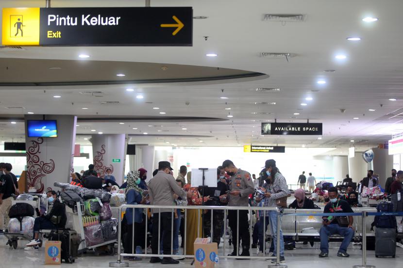 Pekerja Migran Indonesia (PMI) menunggu hasil tes pemeriksaan kesehatan dan dokumen perjalanan saat tiba di Terminal 2 Bandara Internasional Juanda Surabaya di Sidoarjo, Jawa Timur, Sabtu (22/1/2022). PT Angkasa Pura (AP) I (Persero) menargetkan peningkatan kinerja yang optimal tahun ini dibandingkan 2021.