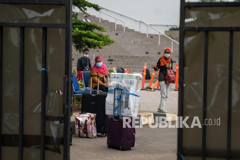 Pekerja Migran Indonesia (PMI) menunggu kendaraan usai menjalani karantina di kompleks Rumah Susun (Rusun) Pasar Rumput, Jakarta. Pemerintah berencana memangkas masa karantina pelaku perjalanan luar negeri menjadi lima hari.