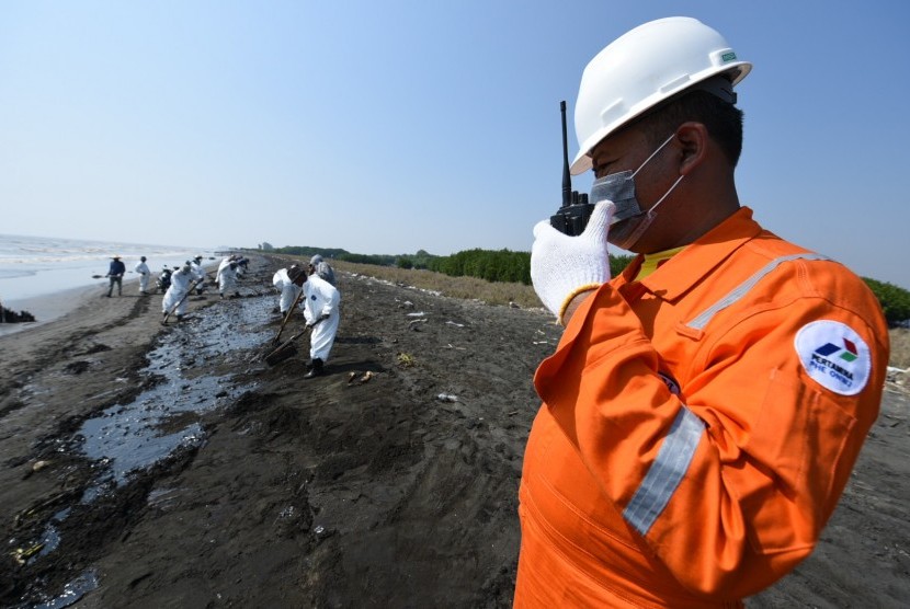 Pekerja Pertamina Hulu Energi Offshore North West Java (PHE ONWJ) memantau sekaligus mengawal warga yang membantu membersihkan ceceran tumpahan minyak di sepanjang Pantai Sedari, Karawang, Jawa Barat, Kamis (1/8/2019).