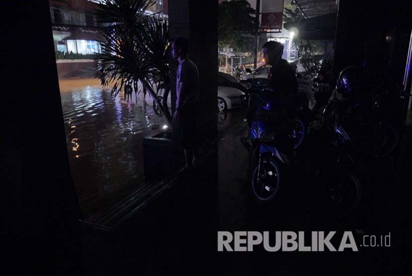 Pekerja pertokoan di sekitar Kemang menunggu banjir surut hingga dini hari, Ahad (28/8). (Foto: Yogi Ardhi/Republika)