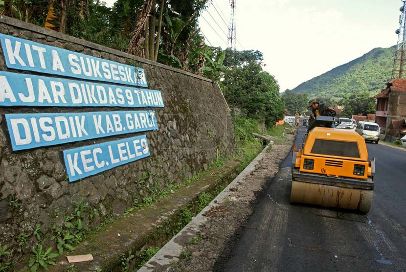 Pekerja proyek perbaikan jalan jalur mudik Jalan raya Tutugan Leles, Kab Garut, Jawa Barat, Senin (13/7). (Republika/Adhi Wicaksono)