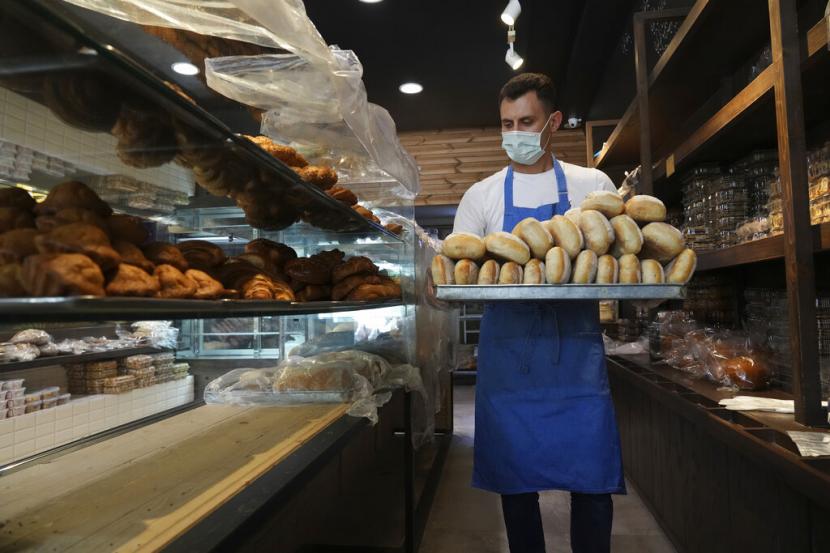 Pekerja roti Mojtaba Motallebi membawa roti di sebuah toko roti di Teheran, Iran, Rabu, 11 Mei 2022. Iran tiba-tiba menaikkan harga sebanyak 300% untuk berbagai bahan pokok seperti minyak goreng, ayam, telur, dan susu pada Kamis.