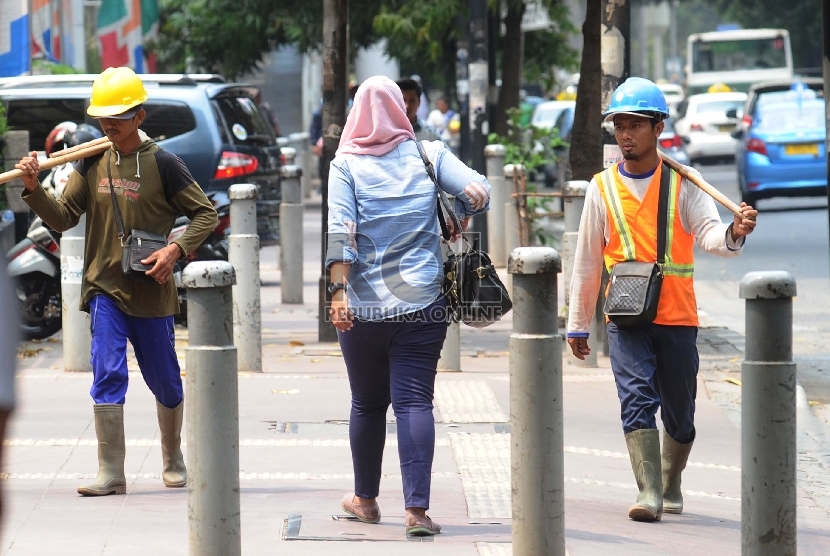  Pekerja sedang berjalan pada kawasan pusat bisnis di Jl Sudirman, Jakarta.