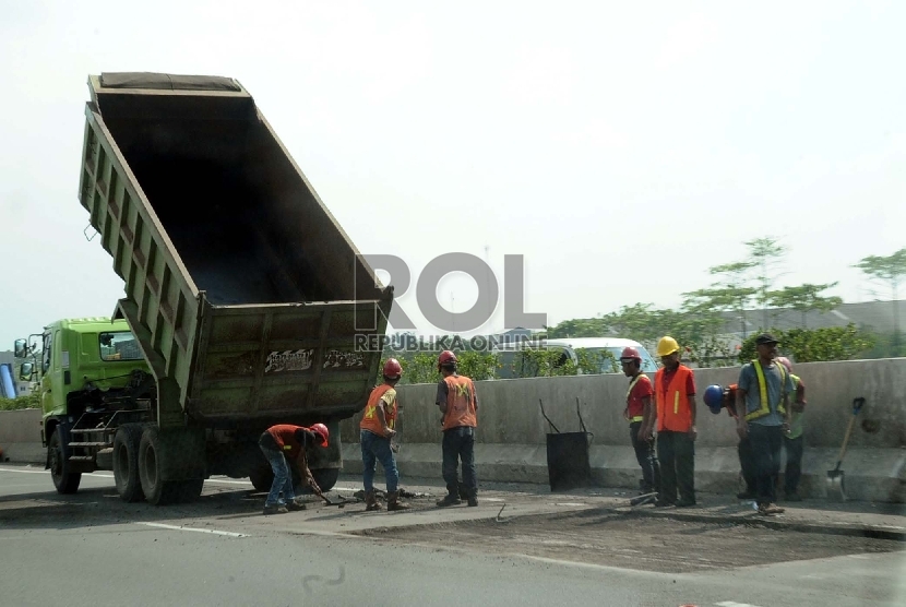 Pekerja sedang melakukan perbaikan di jalan Tol Tangerang-Merak, Banten, Kamis (28/5).