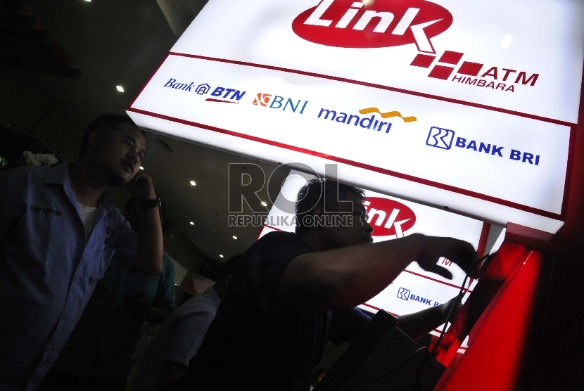 Pekerja sedang memasang unit baru ATM Himpunan Bank-Bank Milik Negara (Himbara) di perkantoran, Jakarta.