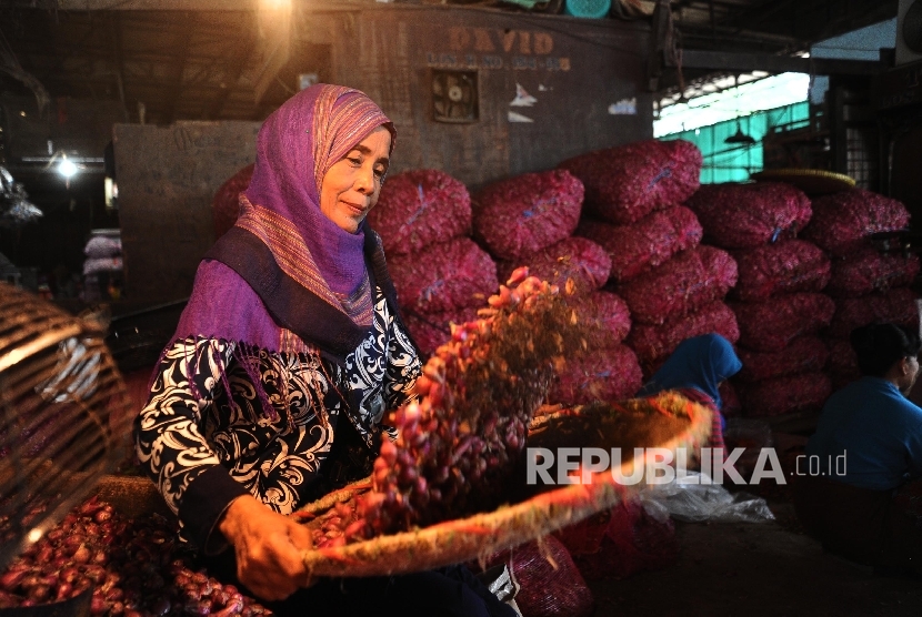 Pekerja sedang membersihkan bawang merah di pasar Induk, Jakarta, Selasa (19/4). (Republika/Tahta Aidilla )