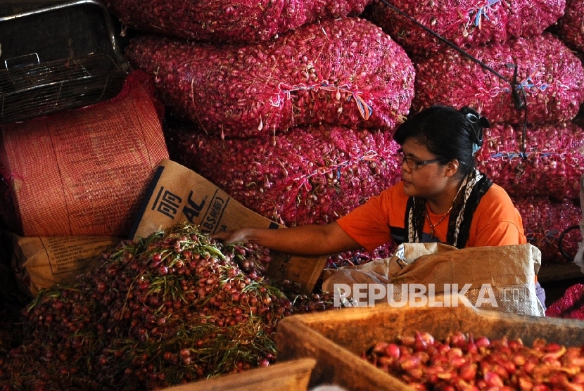Pekerja sedang membersihkan bawang merah di pasar Induk, Jakarta. (Republika/Tahta Aidilla )