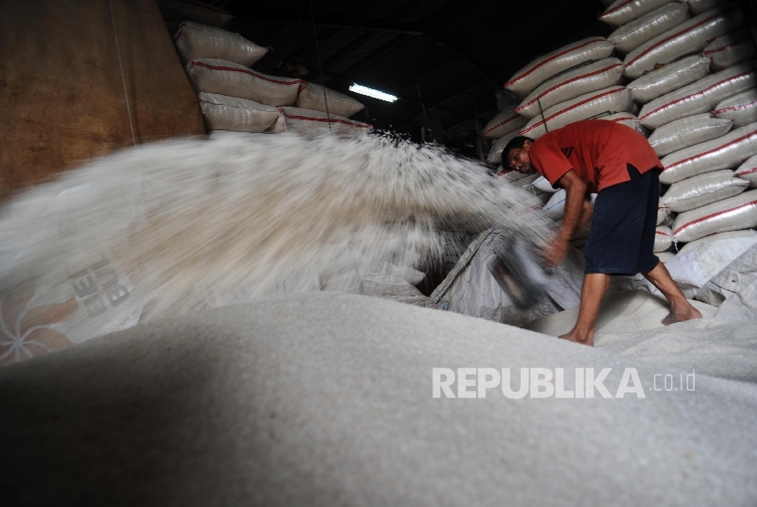 Pekerja sedang membersihkan beras di Pasar Induk Cipinang, Jakarta, Senin (26\12).