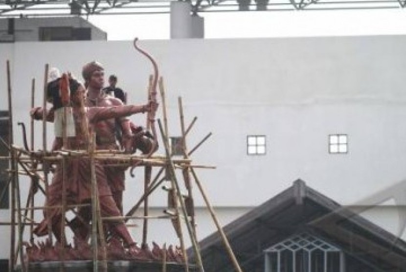 Pekerja sedang memperbaiki pantung simbol Stadion Manahan Solo. Stadion ini menjadi salah satu venue ASEAN Paragames 2011.