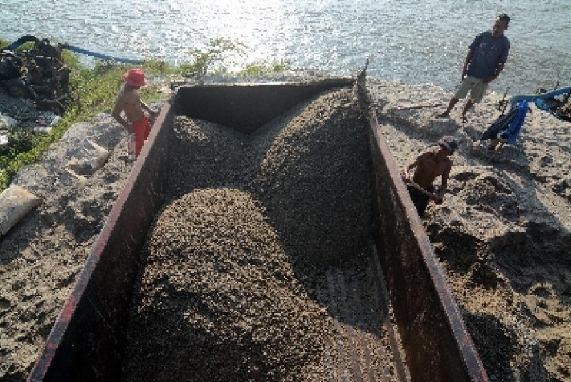 Pekerja sedang mengangkut pasir sebagai salah satu hasil pertambangan.