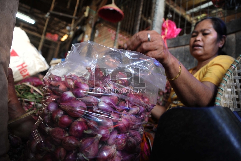 Pekerja sedang mengupas bawang merah di pasar Induk, Jakarta. 