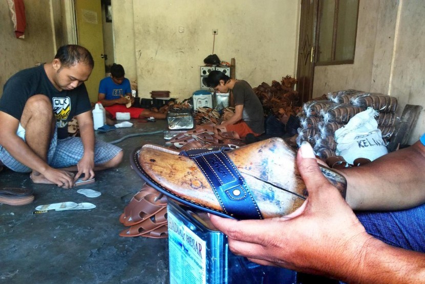 Pekerja sedang menyelesaikan pembuatan sandal di salah satu sentra pembuatan sandal di Kampung Cipicung, Kecamatan Cihideung, Kota Tasikamlaya, Jawa Barat.