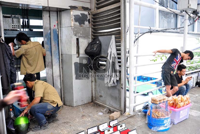   Pekerja tengah memperbaiki lift di halte Busway Sarinah, Jakarta Pusat, Senin (17/12).  (Rakhmawaty La'lang)