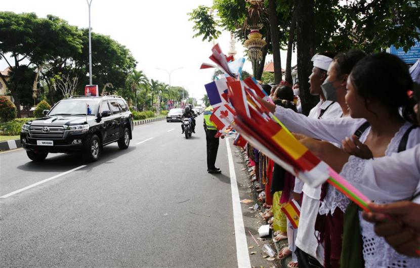  Pelajar Bali mengibarkan bendera negara anggota G20 saat kedatangan para pemimpin G20, di sepanjang jalan dekat bandara Internasional Ngurah Rai di Bali, Senin,  14 November 2022. KTT Kepala Negara dan Pemerintahan Kelompok Dua Puluh (G20) ke-17 akan diadakan di Bali dari tanggal 15 hingga 16 November 2022. 