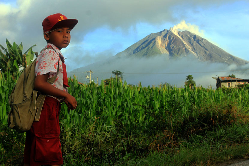  Pelajar berangkat menuju sekolahnya yang berada di sekitar kaki Gunung Sinabung di Desa Berastepu, Karo, Sumut, Kamis (7/11).   (Antara/Irsan Mulyadi)