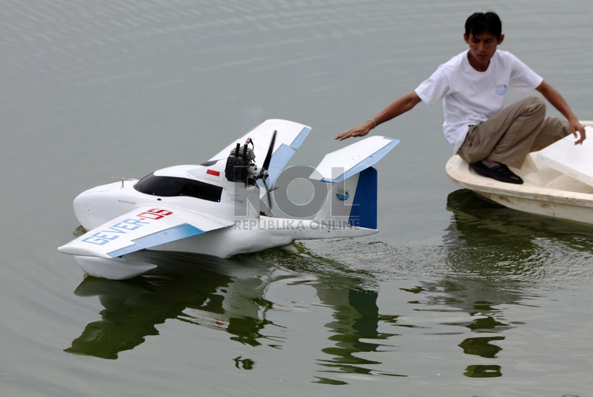 Pelajar dari Institut Maritim Indonesia (IMI) melakukan uji coba prototipe 'Perahu Terbang' (Flyingboat) di Situ Gintung, Ciputat, Tangerang Selatan, Banten, Rabu (18/12).   (Republika/Yasin Habibi)