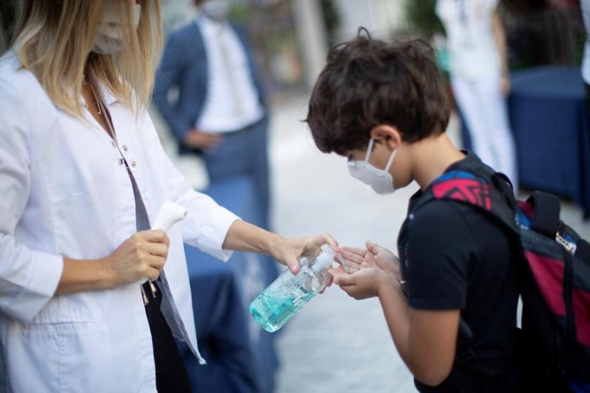 Pelajar International American School di Barcelona, Spanyol tampak mengenakan masker saat ke sekolah, September 2020. Peneliti mengingatkan, anak-anak sebaiknya tak dipaksa mengenakan masker.